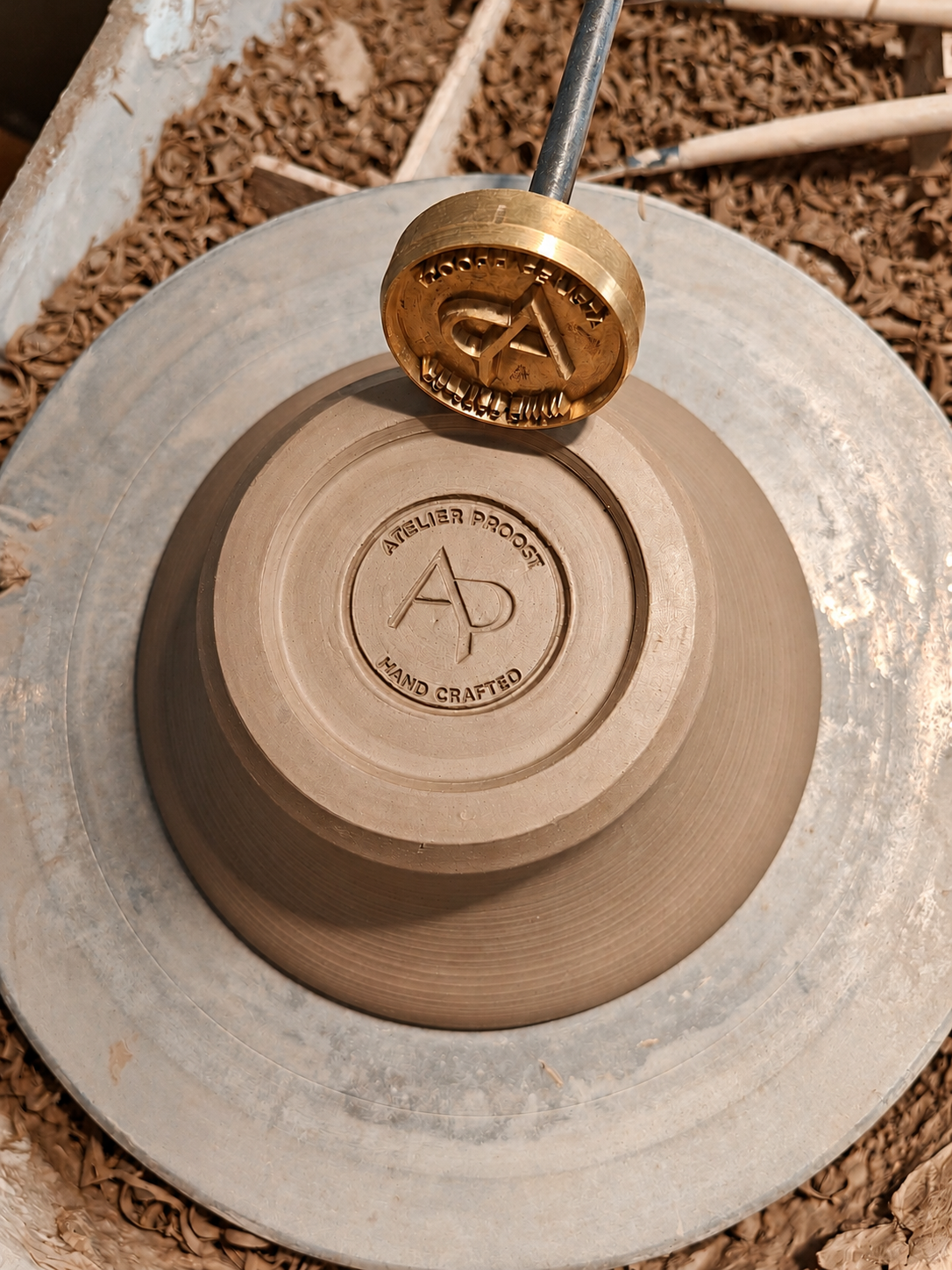 The Atelier Proost maker’s mark impressed into the underside of a ceramic piece